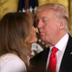 President Trump, a human man, leans in to give his wife, a human woman, a kiss that regular human couples might engage in (Photo by Chip Somodevilla/Getty Images)